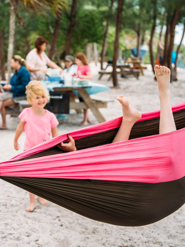 Photo of kids playing in a hammock with feet sticking out.
