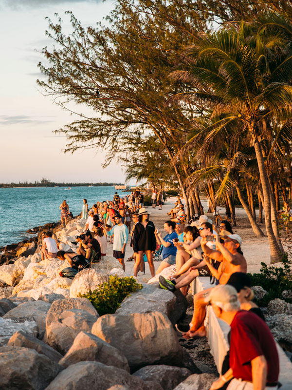 photo of a bunch of beach tourists enjoying the sunset.