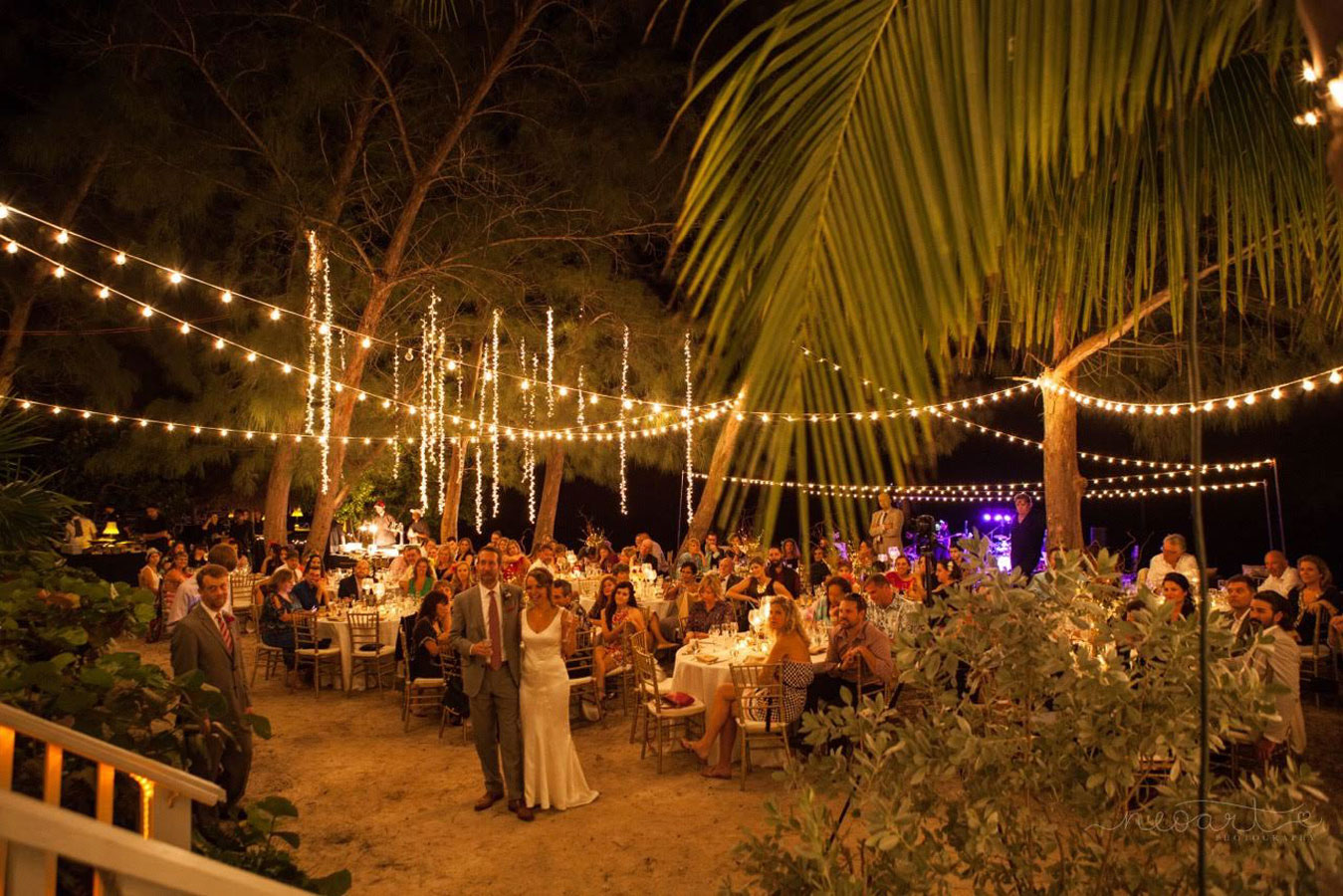Photo of a wedding reception on a beach at nighttime.